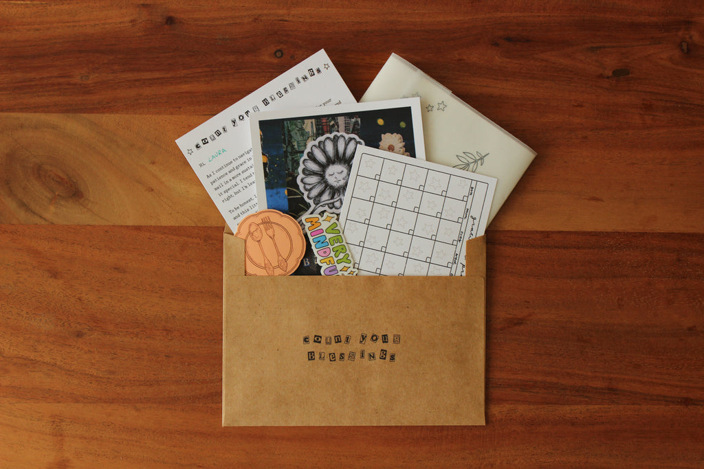 Open brown envelope with stationery items on a wooden surface