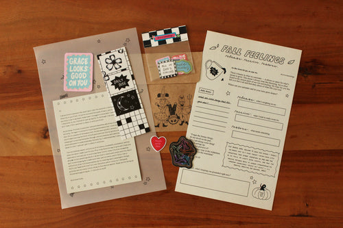Stationery items including cards, stickers, and a letter on a wooden surface