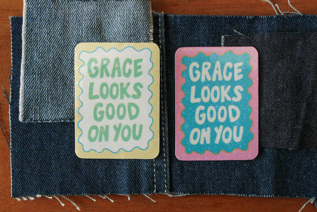 Two stickers with 'GRACE LOOKS GOOD ON YOU' text on denim fabric.