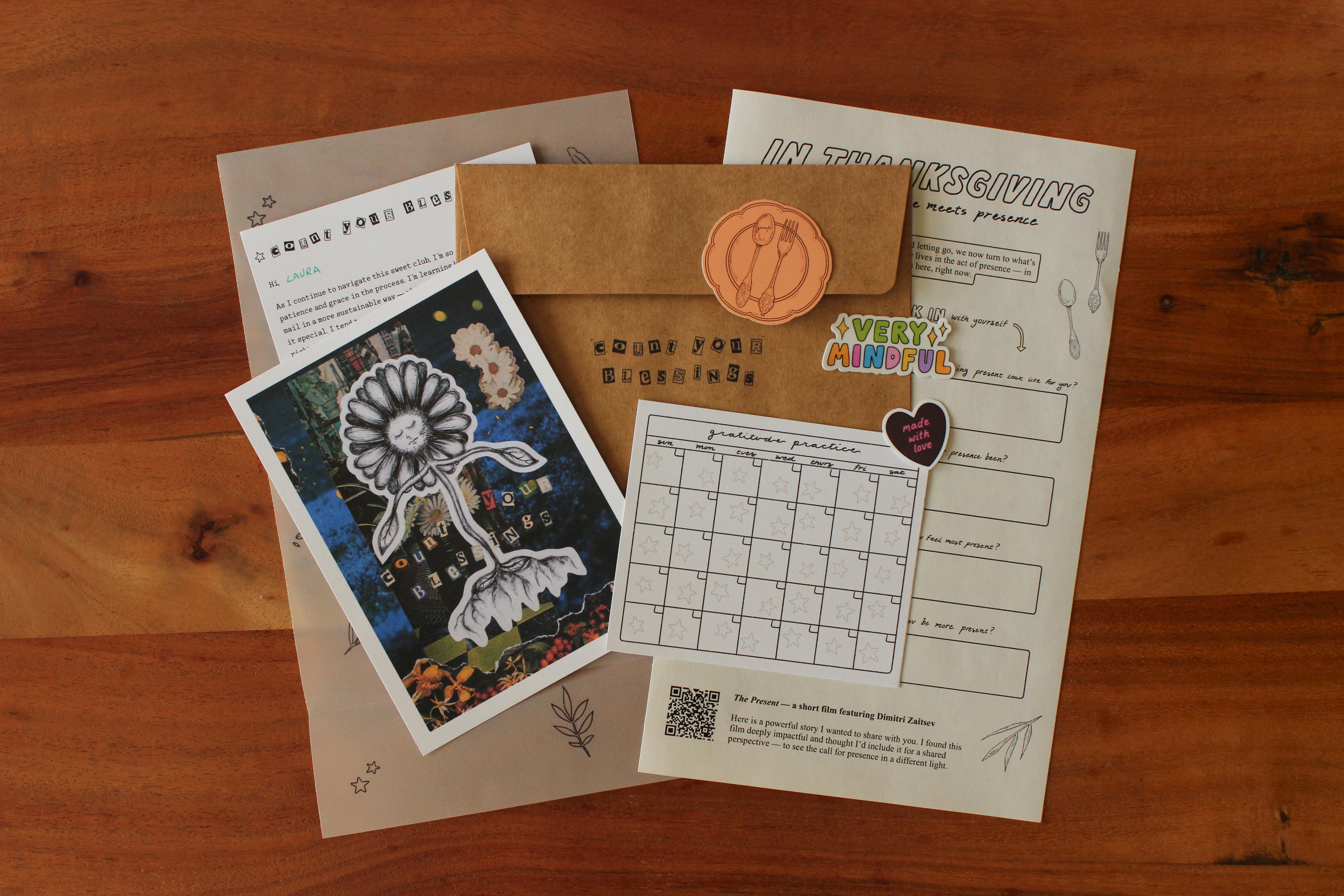 Collection of stationery items including a card, envelope, and printed sheets on a wooden surface.